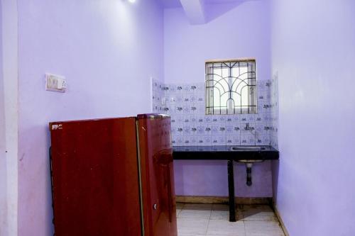 a bathroom with a red refrigerator and a sink at Hotel O Mahamaya Holiday Inn in Goa