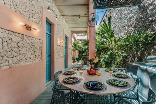 a table with plates and wine glasses on a patio at A-Wotoch Centro de Mérida in Mérida