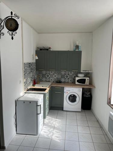 une cuisine avec un lave-linge et un lave-linge dans l'établissement Jolie studio meublé tout équipé, à Châlons-en-Champagne