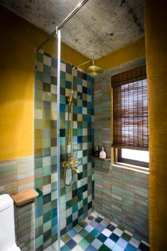a bathroom with a shower with colorful tiles at Hoi An Hidden Boat in Hoi An