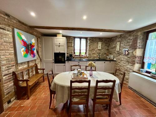 une cuisine et une salle à manger avec une table et des chaises dans l'établissement Cottage chez Emilie, à Beaulieu