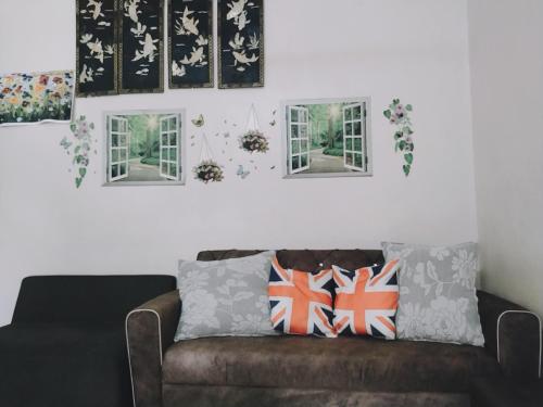 a living room with a brown couch and windows at Homestay 5095 bandar Putra Kulai Johor in Kulai