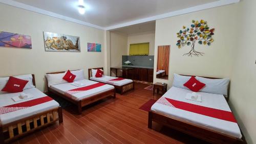 a hotel room with three beds and a television at Roccksar Pension House in Puerto Princesa City