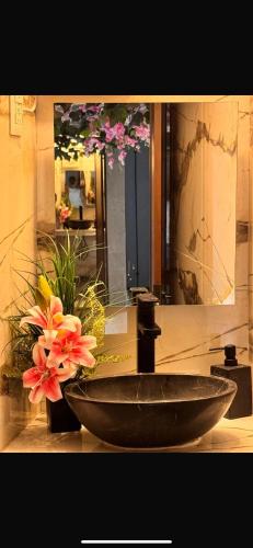 a bathroom sink with flowers in front of a mirror at Hotel Casa KARLOTTA in San Miguel de Allende