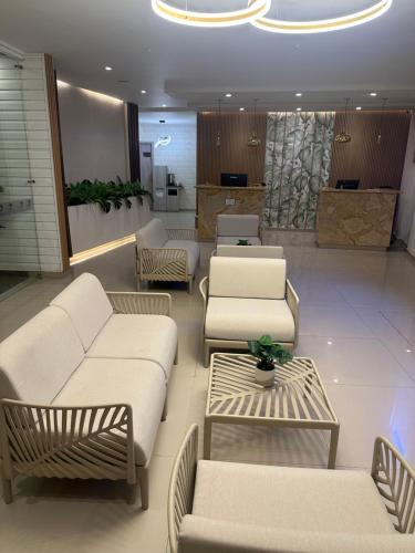 a waiting room with white couches and tables in a lobby at Oasis Hotel in San Andrés