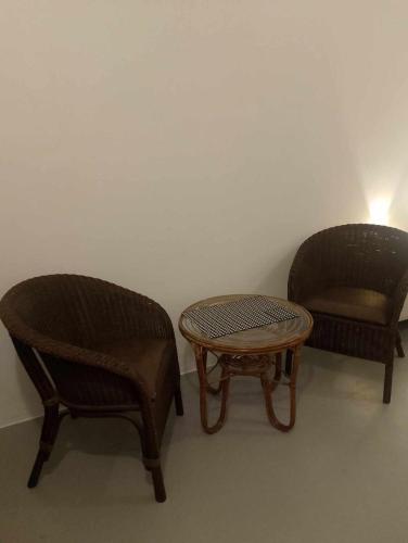 two chairs and a table in a room at Valor Ain Villa in Tarlac