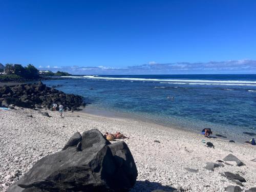 a person laying on a beach near the water at Les Bungalows du Sud 1 in Saint-Pierre