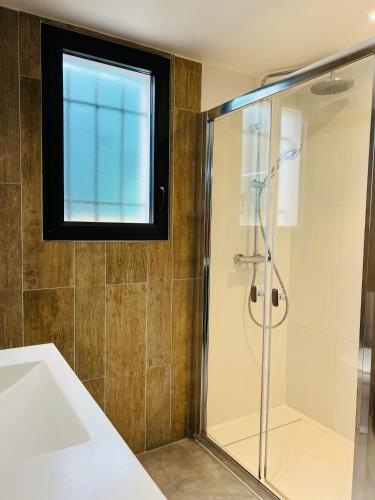 La salle de bains est pourvue d'une douche et d'une fenêtre. dans l'établissement Maison 3 chambres proche de la mer, à La Ciotat