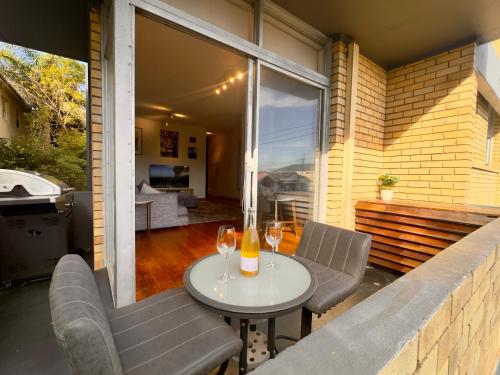 a patio with a table and chairs and a balcony with a view at Sunny Bondi Retreat: Beach & Culture Unite! in Sydney