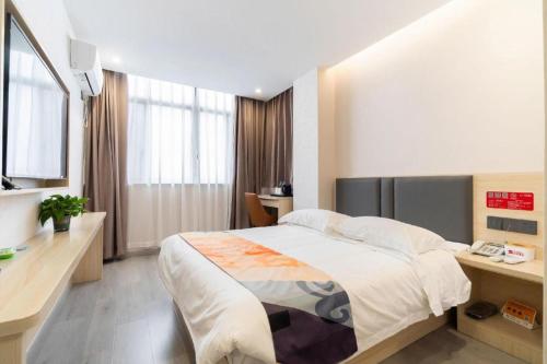 a bedroom with a large bed and a desk at Shell Hotel Wuxi Huishan District Chang'an Town in Wuxi
