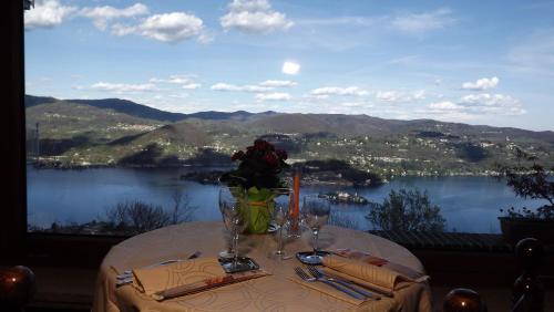 a table with a view of a lake and mountains at Hotel Panoramico lago d'Orta in Madonna del Sasso