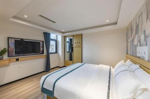a bedroom with a large bed and a flat screen tv at City Comfort Inn Kunming Dashuying Yejin Hospital Wangdaqiao in Kunming