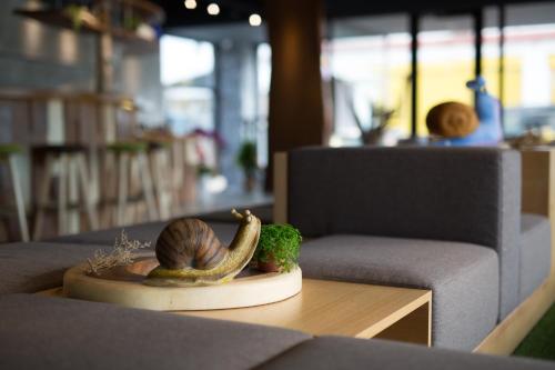 a snail sitting on a table next to a chair at Meci Hotel in Hualien City