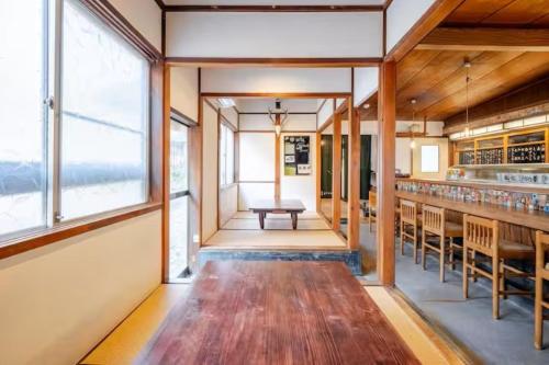 a dining room with a table and some windows at Guesthouse giwa - Vacation STAY 14271v in Mishima