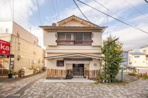 a white building with a window on a street at Guesthouse giwa - Vacation STAY 14271v in Mishima