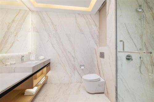 a bathroom with a sink and a toilet and a shower at Courtyard by Marriott Ranchi in Rānchī