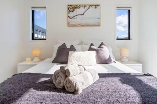 een groot wit bed met een teddybeer erop bij Stadium Suite on Southwark - Luxury in City Centre in Christchurch