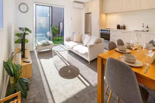 een woonkamer met een eettafel en een keuken bij Stadium Suite on Southwark - Luxury in City Centre in Christchurch