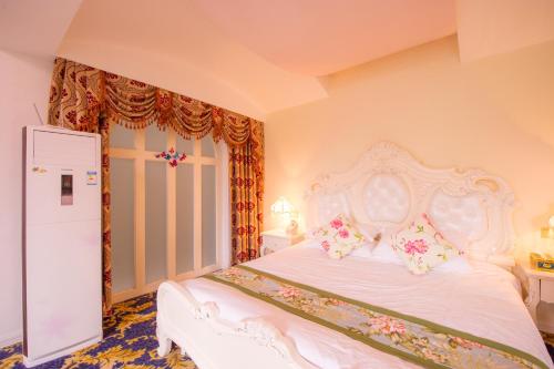 a bedroom with a white bed with flowers on it at Milou Inn in Yangshuo
