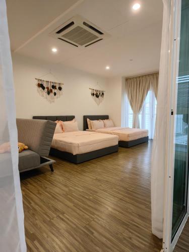 una sala de estar con dos camas y un sofá en Setapak Central KL - Zetapark Zen Suites, en Kuala Lumpur