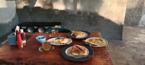 a wooden table with plates of food on it at Iza home stay in Senaru