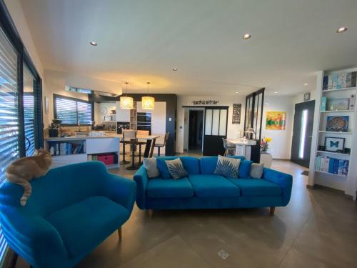 un salon avec un canapé bleu et une cuisine dans l'établissement Villa GANESH à ROYAN, à Royan