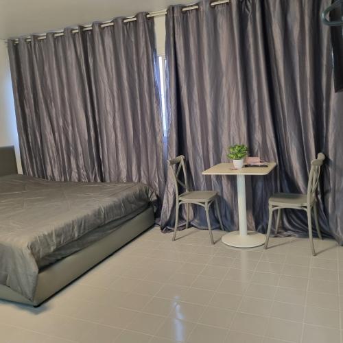 ein Schlafzimmer mit einem Bett und einem Tisch mit Stühlen in der Unterkunft Popular Muang Thong Condo, Building T9, Floor 8, Room 20 in Ban Bang Phang