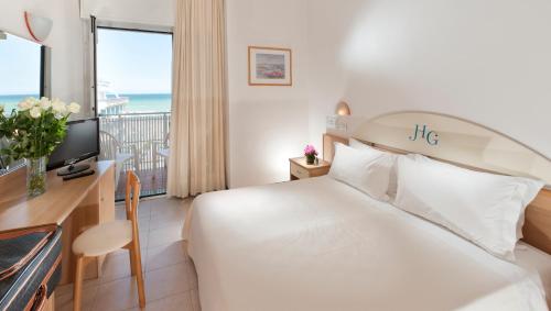 カットーリカにあるHotel Gabbianoのベッドとバルコニー付きのホテルルーム