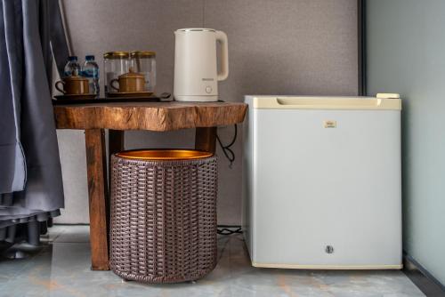クブペンロカンにあるThe Jungle Sunrise Private Room and Jacuzziのテーブルとゴミ箱の横に置かれたコーヒーマシン