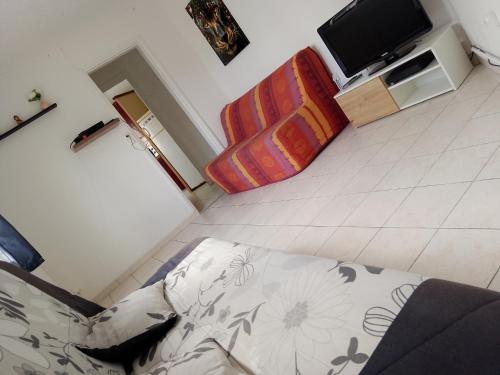 Cette chambre comprend un lit et une télévision. dans l'établissement Maisonnette, à Saintes