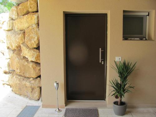 a black front door of a house with a plant at Folco Studio Apartment in Piazza Armerina