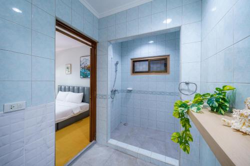 パタヤ・セントラルにあるCozy Gray Gardenの青いタイル張りのバスルーム(シャワー付)、ベッド1台が備わります。