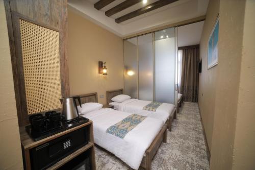 a hotel room with two beds and a mirror at Arda Oasis Hotel in Khiva