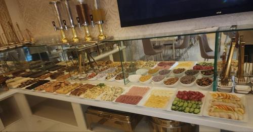 a display case filled with lots of different pastries at Volidam Hotel in Samarkand