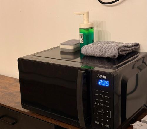 a black microwave with a bottle of soap on top of it at Loft perfecto para foro sol aeropuerto GNP in Mexico City