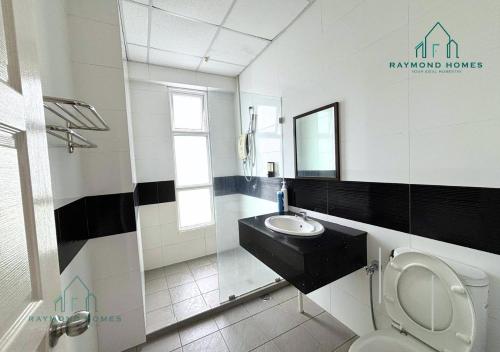 a bathroom with a toilet and a sink and a mirror at Gurney Drive Mansion One Serviced Apartment in George Town