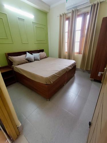リシケーシュにあるRishidwar Homestayの緑の部屋に大きなベッドが備わるベッドルーム1室が備わります。