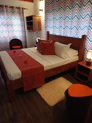 a bedroom with a bed with a red and white blanket at La Banane Rouge Self Catering in La Digue