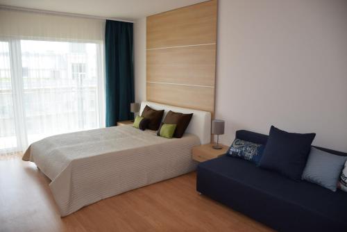 1 dormitorio con 1 cama y 1 sofá en Aqua Apartman Panoráma, en Velence