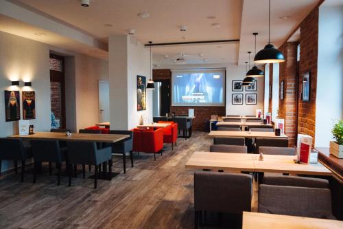 スヴァウキにあるFresco Hostelのテーブルと椅子、大画面のレストランを併設しています。