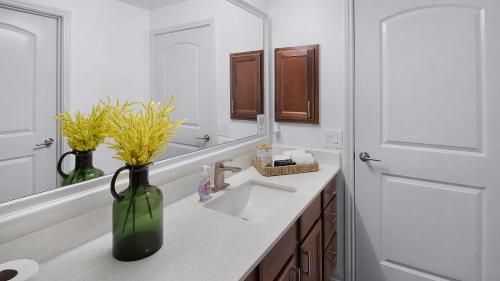 a bathroom with a sink and a vase with flowers at Charming 1BD Haven I Frisco I Pool, Gym, Work Space in Frisco