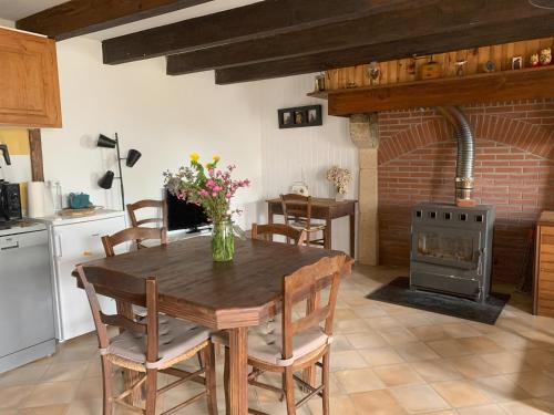 a kitchen and dining room with a table and a stove at La petite maison dans le Sidobre in Fontrieu
