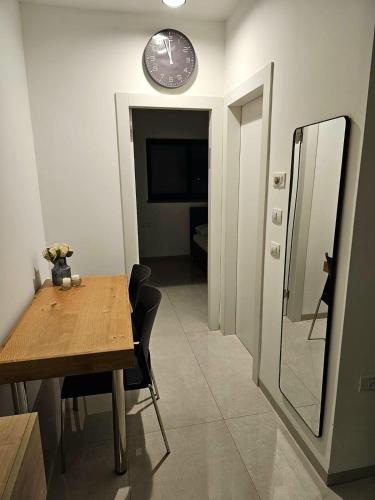 a dining room with a table and a clock on the wall at הנופש הצפוני in Qiryat Shemona