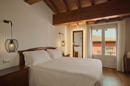 a bedroom with a large white bed and a window at Hotel Le Mura in Lazise