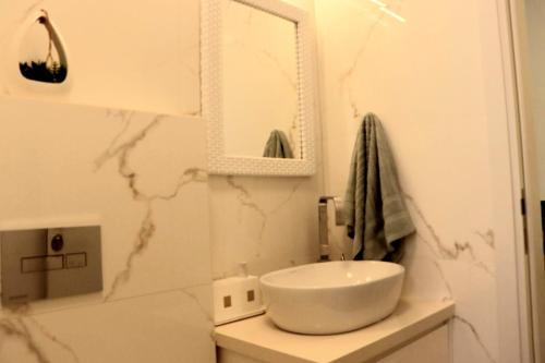 a bathroom with a white sink and a mirror at הנופש הצפוני in Qiryat Shemona