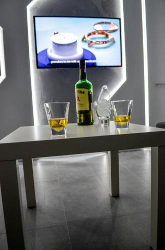 a table with a bottle of wine and two glasses at Apartments Good Night in Niš