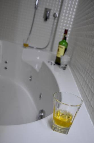 a glass of wine sitting next to a bath tub at Apartments Good Night in Niš