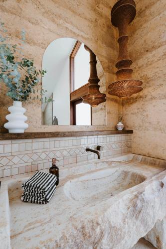 a large marble tub in a bathroom with a mirror at Kavillo Studios in Buckaroo
