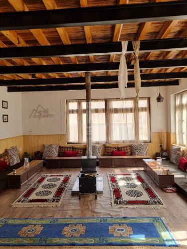a large living room with couches and a rug at Spiti Sojourn - Homestay at the Edge in Kaza