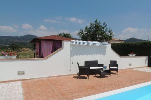 a patio with a table and chairs next to a pool at Agriturismo Il Cavallino Saturnia in Semproniano